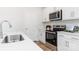 Clean kitchen features white cabinets, stainless steel appliances, quartz countertop, and light flooring at 111 Rustling Waters Dr, Mooresville, NC 28117