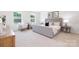 Serene bedroom with two large windows, a gray upholstered bed, and comfortable seating at 111 Rustling Waters Dr, Mooresville, NC 28117
