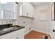 Functional laundry room with storage cabinets, a sink, and stylish tile flooring at 1115 Sugar Creek Rd, Indian Land, SC 29707