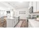 Modern kitchen with white cabinetry, quartz countertops, stainless steel appliances, and an island with bar stool seating at 112 Buoy Ln, Statesville, NC 28677
