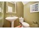 Powder room with pedestal sink, toilet, neutral wall color, and framed mirror at 1126 Snowbird Ln, Waxhaw, NC 28173
