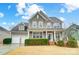Charming two-story home boasts a manicured lawn, attached two-car garage, and inviting front porch at 1126 Snowbird Ln, Waxhaw, NC 28173