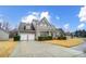 View of a two-story home with attached garage, long driveway, and well-maintained lawn at 1126 Snowbird Ln, Waxhaw, NC 28173