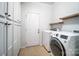 Laundry room with cabinetry, shelving, and updated washer and dryer at 1126 Snowbird Ln, Waxhaw, NC 28173