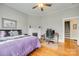 Bedroom featuring a decorative fireplace, hardwood floors, and adjacent workspace, all illuminated by a ceiling fan at 119 Hemphill Ave, Chester, SC 29706