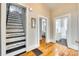 Hallway showcasing hardwood floors, staircase with decorative detail, and entrances to the bathroom and bedroom at 119 Hemphill Ave, Chester, SC 29706