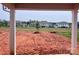 View of leveled backyard with newly planted tree, framed by covered porch columns at 13248 Chopin Ridge Rd, Huntersville, NC 28078