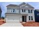 Charming two-story home with light blue siding, a white garage door and black window shutters at 13248 Chopin Ridge Rd, Huntersville, NC 28078
