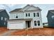 Charming two-story home with a light-colored exterior, a two car garage, and an unfinished front yard at 13248 Chopin Ridge Rd, Huntersville, NC 28078