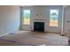 Cozy living room with a fireplace as a focal point and large windows for natural light at 13248 Chopin Ridge Rd, Huntersville, NC 28078