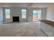 Open-concept living room with fireplace, large windows and slider providing natural light at 13248 Chopin Ridge Rd, Huntersville, NC 28078