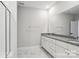 Bathroom featuring dual vanities, granite countertops, and a walk-in shower with glass doors at 143 Carriage Club Dr # 102, Mooresville, NC 28117