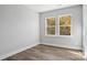 Bedroom with luxury vinyl plank flooring, large window, and neutral paint at 143 Carriage Club Dr # 102, Mooresville, NC 28117