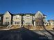Beautiful townhome exteriors, well maintained with welcoming front steps under a clear, sunny sky at 143 Carriage Club Dr # 102, Mooresville, NC 28117