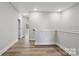 Upstairs hallway featuring luxury vinyl plank flooring with access to bedrooms and bathroom at 143 Carriage Club Dr # 102, Mooresville, NC 28117