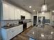 Modern kitchen with stainless steel appliances, granite countertops, and subway tile backsplash at 143 Carriage Club Dr # 102, Mooresville, NC 28117