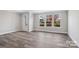 Bright living room with luxury vinyl plank flooring and large windows providing natural light and neighborhood views at 143 Carriage Club Dr # 102, Mooresville, NC 28117
