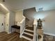 Staircase with white railing and stained wood steps with a view to the entry and other rooms at 143 Carriage Club Dr # 102, Mooresville, NC 28117