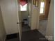Modest bathroom with a toilet, sink, mirror and a red valance over the window at 146 Loomis St, Chester, SC 29706
