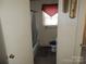 Simple bathroom featuring a toilet, tub/shower and a sink with a red valance over the window at 146 Loomis St, Chester, SC 29706