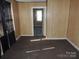 Bedroom featuring wood paneling, carpeted floors, and a window with dark curtains at 146 Loomis St, Chester, SC 29706