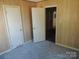 Bedroom featuring wood panel walls, closet, and doorway into another room at 146 Loomis St, Chester, SC 29706