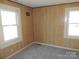 Bedroom featuring wood panel walls and two windows for natural light at 146 Loomis St, Chester, SC 29706