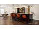 Basement bar area featuring dark wood cabinetry, granite countertops, and stylish seating at 1506 Venetian Way Dr, Waxhaw, NC 28173