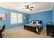Stylish bedroom with blue walls, a ceiling fan, and a window providing ample natural light at 1506 Venetian Way Dr, Waxhaw, NC 28173