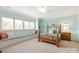 Comfortable bedroom with window seat, brass bed frame, neutral carpet, and soft blue walls at 1506 Venetian Way Dr, Waxhaw, NC 28173