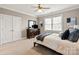Cozy bedroom boasts a double-door closet, dresser with TV, and a comfy bed beneath a bright window at 1506 Venetian Way Dr, Waxhaw, NC 28173