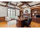 Home office with coffered ceiling, a window, built-in bookshelves, and a large wooden desk at 1506 Venetian Way Dr, Waxhaw, NC 28173
