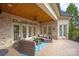Covered outdoor patio with wicker furniture, ceiling fan, and brick facade at 1506 Venetian Way Dr, Waxhaw, NC 28173