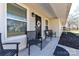 Inviting front porch features black chairs, a decorative wreath on the door, and ample natural light at 1511 Liberty Ave, Albemarle, NC 28001