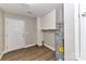 Laundry room with wood floors, built-in cabinets, and hot water tank at 1511 Liberty Ave, Albemarle, NC 28001