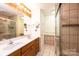 Bathroom featuring a double sink vanity, tile flooring, and glass shower enclosure at 1552 10Th Street Nw Pl, Hickory, NC 28601