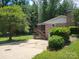 Brick home with a large screened deck and concrete driveway surrounded by lush greenery at 1552 10Th Street Nw Pl, Hickory, NC 28601
