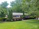 Charming one-story home featuring a metal roof, blue shutters, and beautiful landscaping at 1552 10Th Street Nw Pl, Hickory, NC 28601