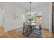 Charming dining room with hardwood floors, a modern chandelier, and views of the front yard at 1824 Haines St, Charlotte, NC 28216