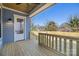 Newly built porch with wood flooring and painted blue siding on a sunny day at 1824 Haines St, Charlotte, NC 28216