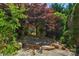 Backyard stone patio area, surrounded by lush landscaping, offering a private outdoor space at 3009 Scottcrest Way, Waxhaw, NC 28173