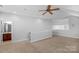 An open bonus room with neutral walls and carpeting, a ceiling fan, and access to a full bathroom at 3009 Scottcrest Way, Waxhaw, NC 28173
