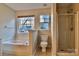 Bright bathroom features a soaking tub, glass shower, and a toilet at 3016 Secret Garden Ct, Indian Trail, NC 28079