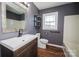 Stylish bathroom featuring modern fixtures, dark gray walls, and wood flooring at 3029 Wendover Nw Rd, Concord, NC 28027