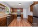 Modern kitchen featuring stainless steel appliances, tile backsplash, and dark wood cabinets at 3029 Wendover Nw Rd, Concord, NC 28027