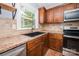 Close-up of kitchen featuring stainless steel appliances, tile backsplash, and dark wood cabinets at 3029 Wendover Nw Rd, Concord, NC 28027