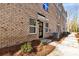 Exterior entrance of brick townhome with door awning, exterior light, and sidewalk at 3816 Odom Way, Charlotte, NC 28216
