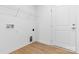 Bright laundry room featuring white walls, wooden floors, and a wire shelving unit above the connections at 3816 Odom Way, Charlotte, NC 28216