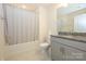 Well-lit bathroom featuring a shower-tub combo with granite countertops and gray cabinets at 4242 Plumeria Way, Fort Mill, SC 29707