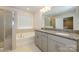 Bathroom featuring double sinks, granite countertops, with separate tub and shower at 4242 Plumeria Way, Fort Mill, SC 29707